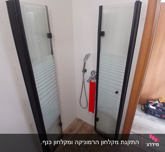 מקלחון פינתי עם פרופיל שחור וזכוכית מעוטרת בחדר רחצה
